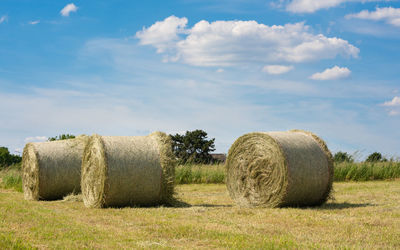 Hay bales on field against sky