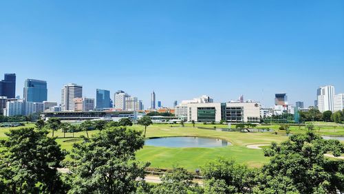 Buildings in city against clear blue sky