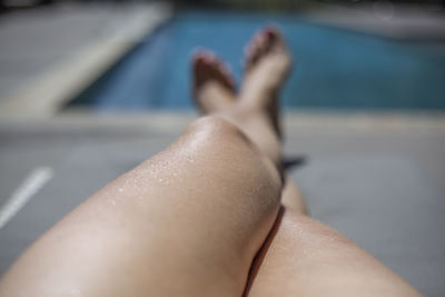Low section of woman lying on swimming pool