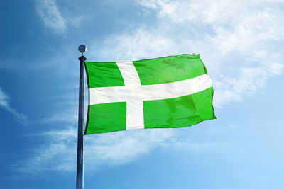 Low angle view of flag against blue sky