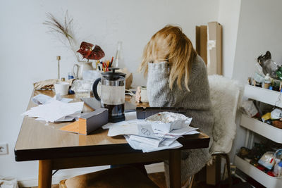 Businesswoman with mental disorder sitting on chair in living room