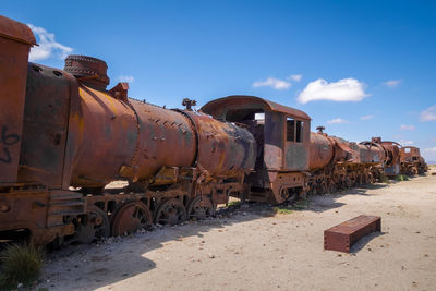 Abandoned train on land against sky