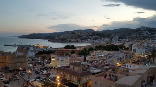 High angle view of townscape by sea against sky
