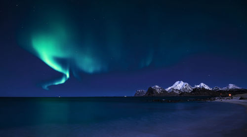 Scenic view of snowcapped mountains against sky at night