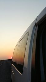 Close-up of airplane against sky during sunset