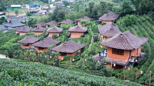 Houses on field against buildings