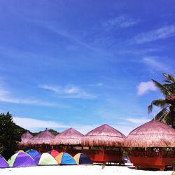 Multi colored umbrellas on beach against blue sky