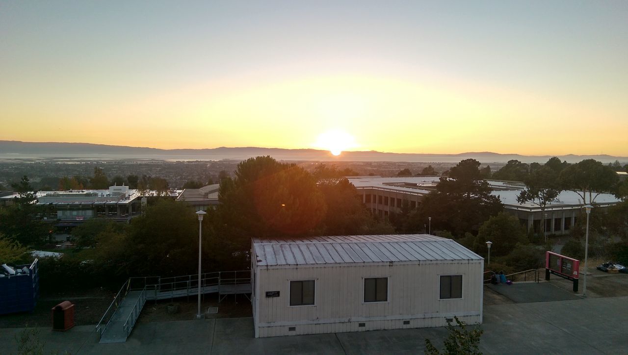 sunset, building exterior, architecture, built structure, sun, tree, house, orange color, residential building, residential structure, clear sky, high angle view, sunlight, sky, residential district, city, copy space, town, nature, outdoors