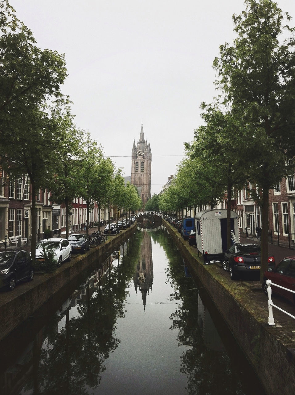 architecture, building exterior, built structure, water, tree, canal, clear sky, waterfront, reflection, city, transportation, river, travel destinations, incidental people, day, travel, famous place, sky, tower, outdoors