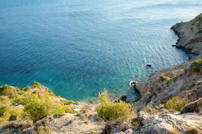 High angle view of cliff by sea against sky