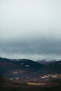 Scenic view of mountains against cloudy sky