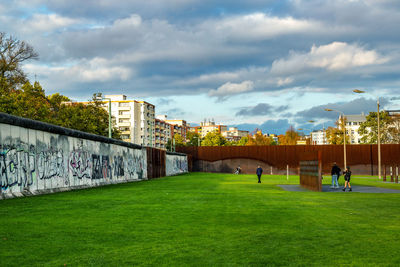 Houses on field against cloudy sky