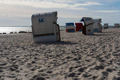Hooded beach chair on shore against sky
