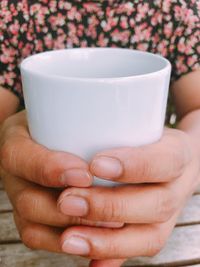 Close-up of hand holding coffee cup