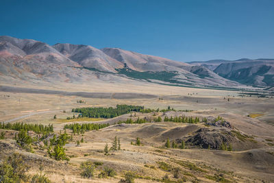 Scenic view of landscape and mountains against clear blue sky