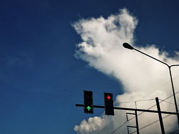 Low angle view of road signal against blue sky