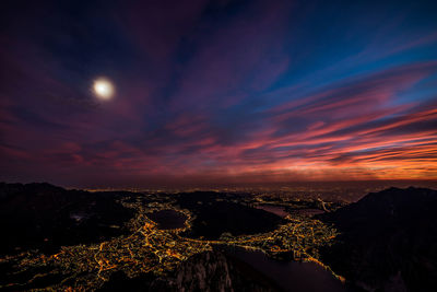 Aerial view of illuminated landscape against sky at sunset