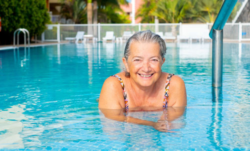 Portrait of a smiling woman swimming in pool