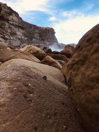 Surface level of rocks on shore against sky