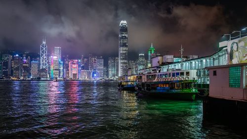 Illuminated modern buildings at victoria harbour in city at night