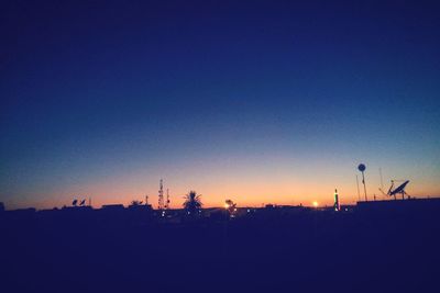 Silhouette of windmill against clear sky at sunset