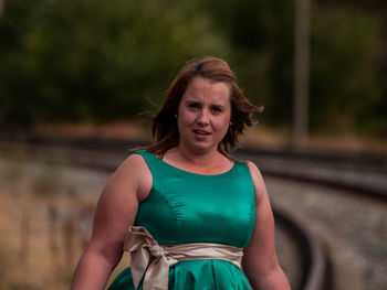 Portrait of beautiful overweight woman standing at railroad track