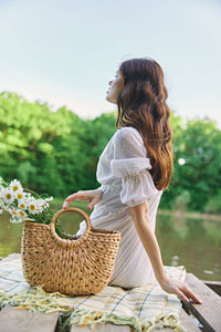 Rear view of young woman sitting on table