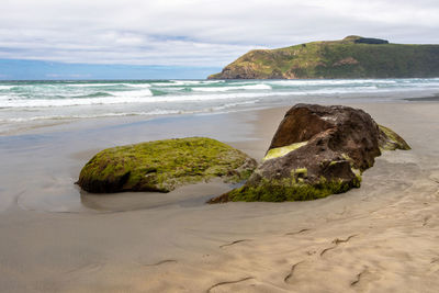 Rocks on beach against sky