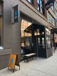 Information sign on sidewalk by building in city