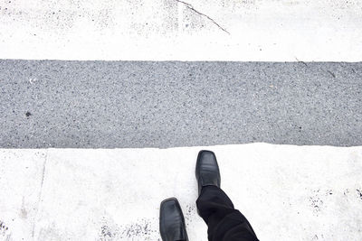 Low section of man standing on road