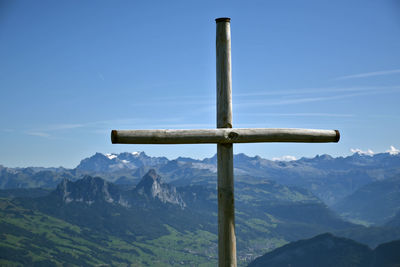 Cross on mountains against sky