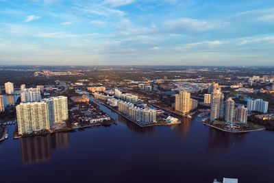 High angle view of buildings by river against sky