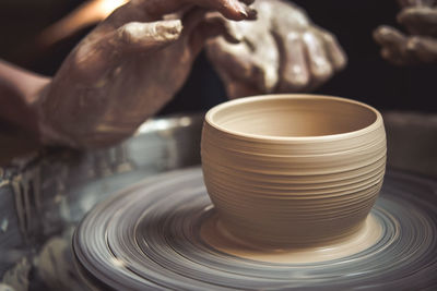 Creating vase of white clay close-up. master crock.the sculptor in the workshop makes a jug