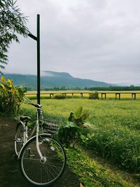 Bicycle on field against sky