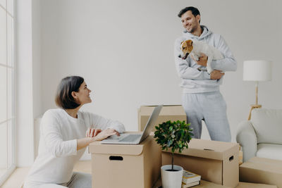 Smiling man talking to woman using laptop