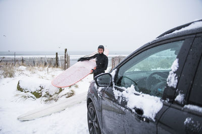 Woman going surfing during winter snow