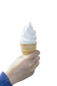 Close-up of hand holding ice cream against white background