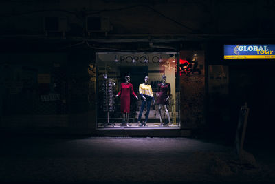 People standing on illuminated road at night