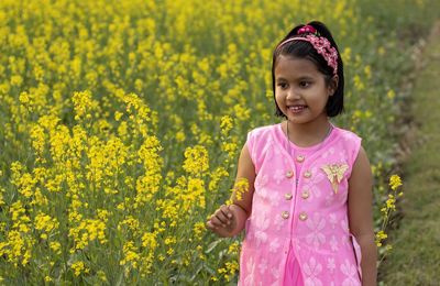 Portrait of smiling girl standing on field