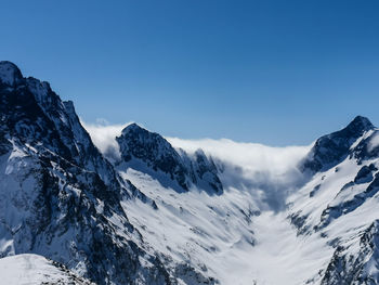 Scenic view of snowcapped mountains against clear blue sky