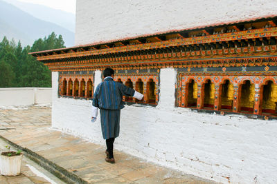 Full length rear view of man walking in historical building