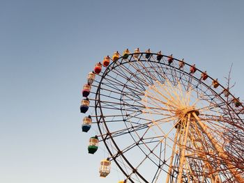 Low angle view of ferris wheel against clear sky