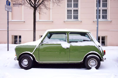 Side view of car parked on street against building