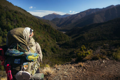 Rear view of man sitting on mountain