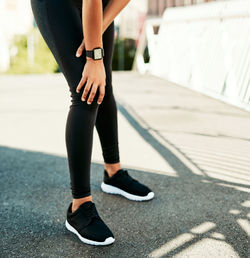 Low section of woman walking on footpath