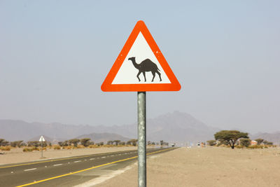 Road sign against clear sky