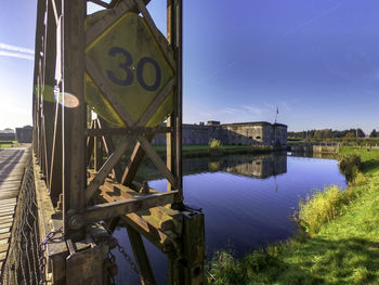 Bridge over river against clear blue sky