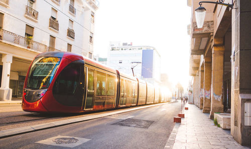 Tram on street in city against sky