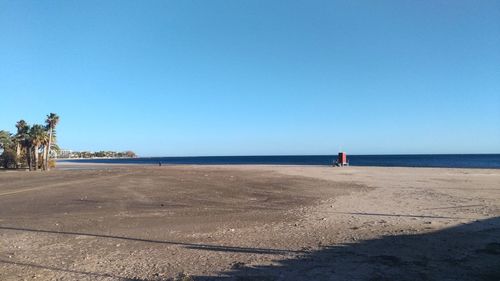 Scenic view of beach against clear blue sky