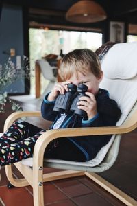 Full length of boy sitting at home